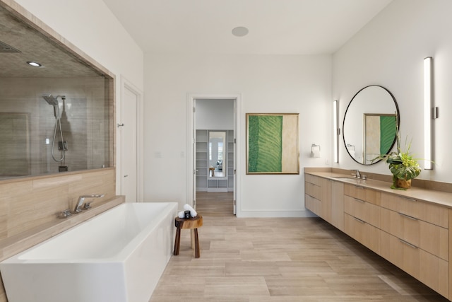 bathroom featuring separate shower and tub, hardwood / wood-style floors, and vanity