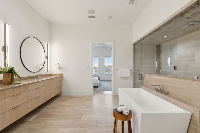 bathroom with vanity and shower with separate bathtub