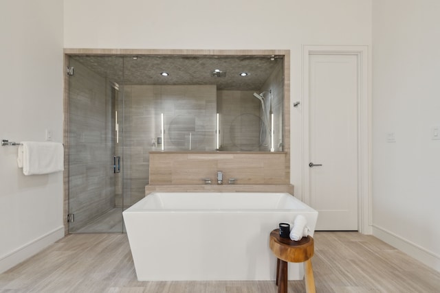 bathroom featuring hardwood / wood-style floors and plus walk in shower