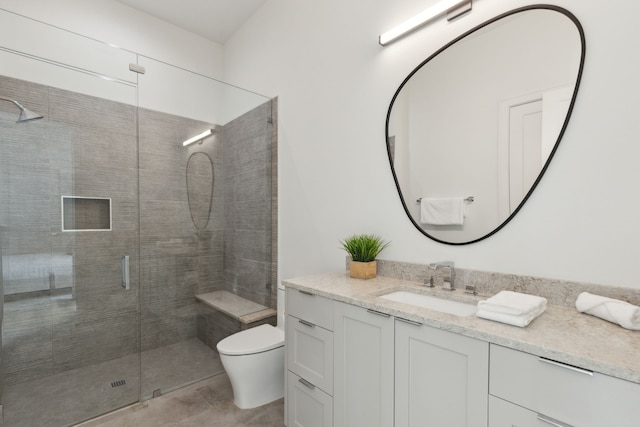 bathroom with vanity, toilet, and a shower with door