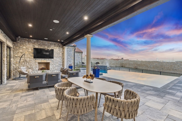 view of patio with an outdoor living space with a fireplace