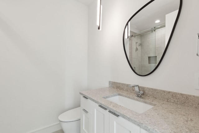 bathroom featuring vanity, toilet, and an enclosed shower