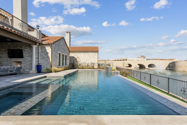 view of pool featuring a patio and an outdoor stone fireplace