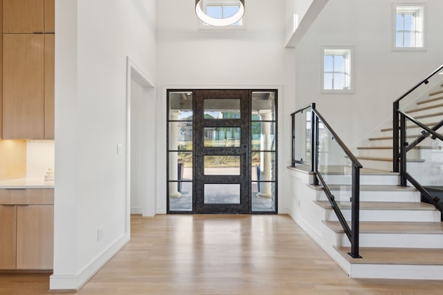 entrance foyer featuring a high ceiling and light hardwood / wood-style flooring