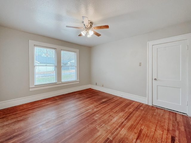 unfurnished room with hardwood / wood-style flooring, ceiling fan, and a textured ceiling