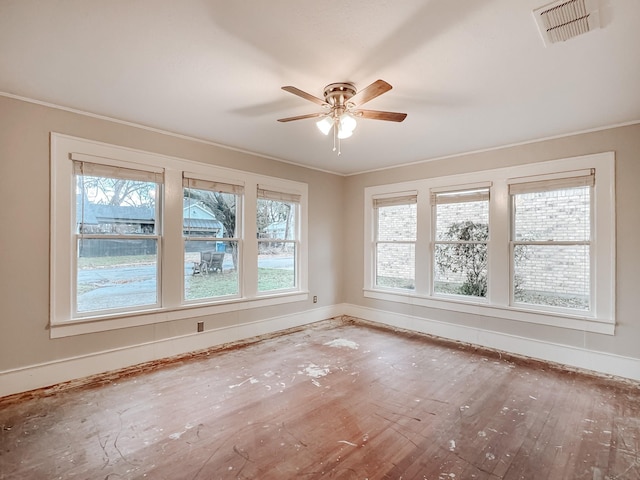 spare room with hardwood / wood-style floors, ceiling fan, and crown molding