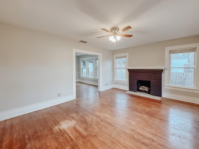 unfurnished living room with a fireplace, light hardwood / wood-style floors, and ceiling fan