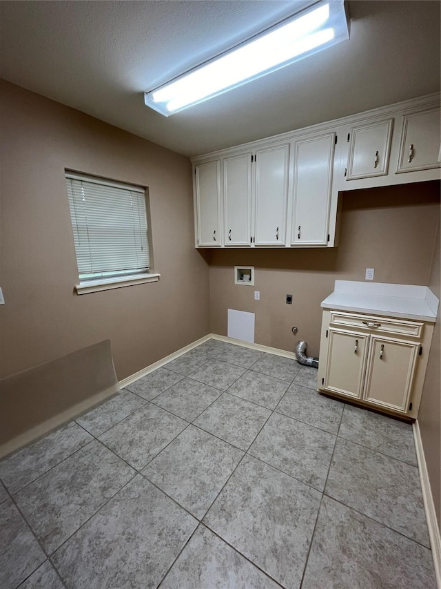 washroom with gas dryer hookup, light tile patterned flooring, hookup for a washing machine, baseboards, and cabinet space