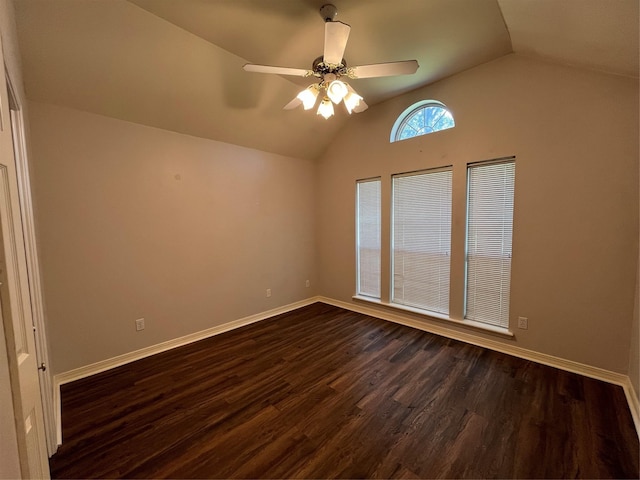 spare room with dark wood-type flooring, lofted ceiling, and baseboards