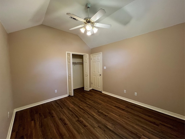 unfurnished bedroom with lofted ceiling, visible vents, baseboards, a closet, and dark wood finished floors