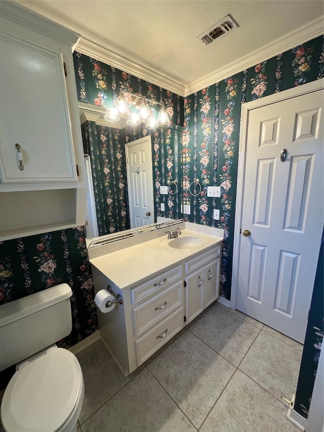 bathroom with tile patterned floors, vanity, toilet, and ornamental molding