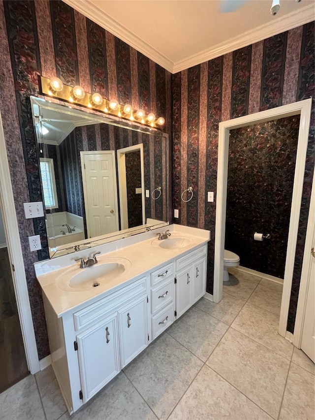 bathroom featuring crown molding, double vanity, a sink, and wallpapered walls