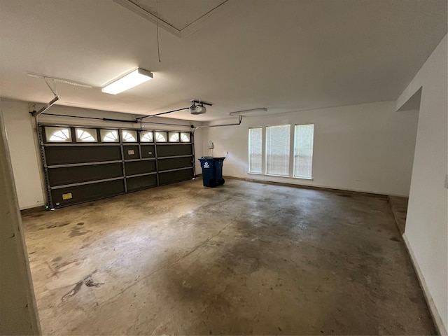 garage featuring a garage door opener and baseboards