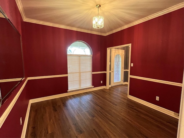 unfurnished room featuring crown molding, dark hardwood / wood-style flooring, and a notable chandelier