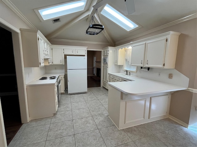 kitchen featuring sink, kitchen peninsula, vaulted ceiling, white fridge, and white cabinetry