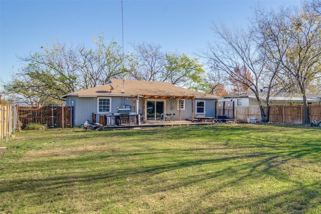 rear view of house featuring a wooden deck and a yard