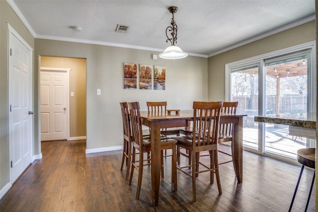 dining area with dark hardwood / wood-style flooring, ornamental molding, and a textured ceiling