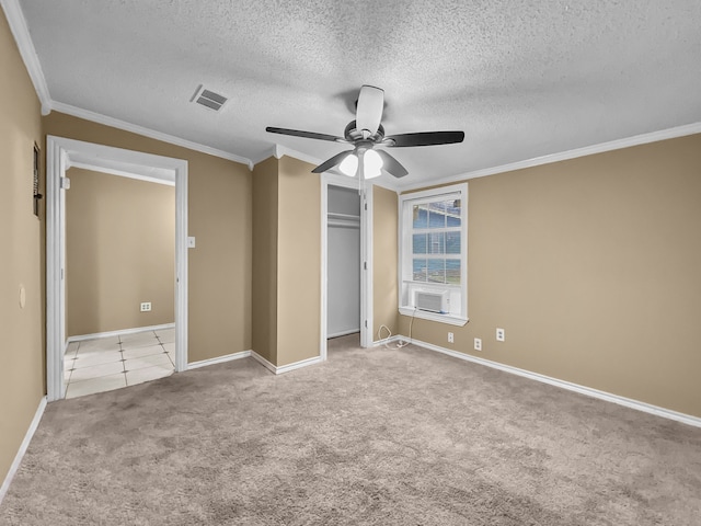 unfurnished bedroom with light carpet, cooling unit, ceiling fan, ornamental molding, and a textured ceiling