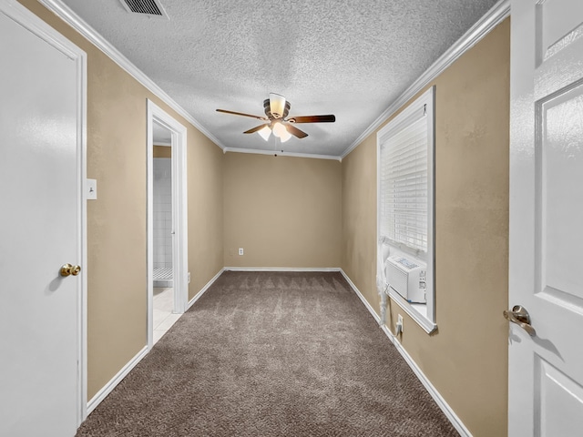 carpeted spare room featuring a textured ceiling, cooling unit, crown molding, and ceiling fan