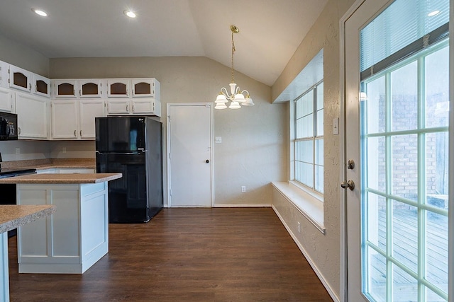 kitchen featuring a healthy amount of sunlight, black appliances, decorative light fixtures, white cabinetry, and lofted ceiling