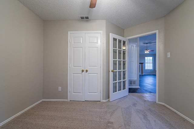 empty room with a textured ceiling and light carpet