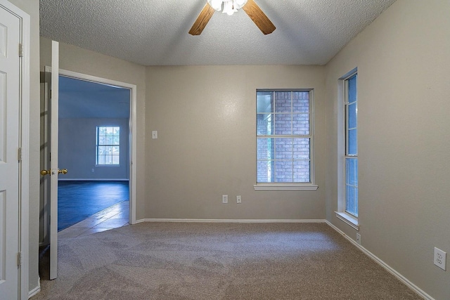 carpeted empty room featuring ceiling fan and a textured ceiling