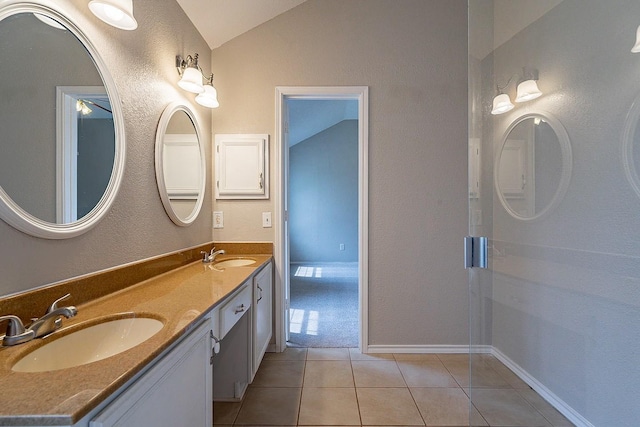 bathroom featuring tile patterned floors, vanity, and vaulted ceiling