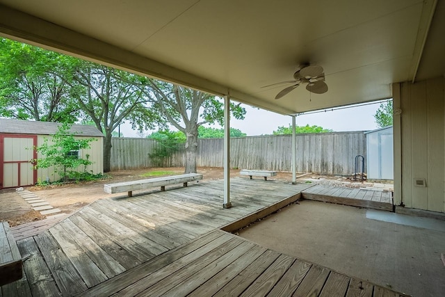 wooden deck featuring ceiling fan and a storage unit