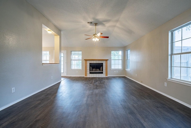 unfurnished living room featuring dark hardwood / wood-style flooring, a textured ceiling, ceiling fan, a fireplace, and lofted ceiling