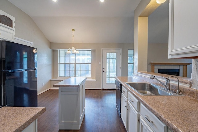 kitchen with a center island, lofted ceiling, black appliances, sink, and hanging light fixtures