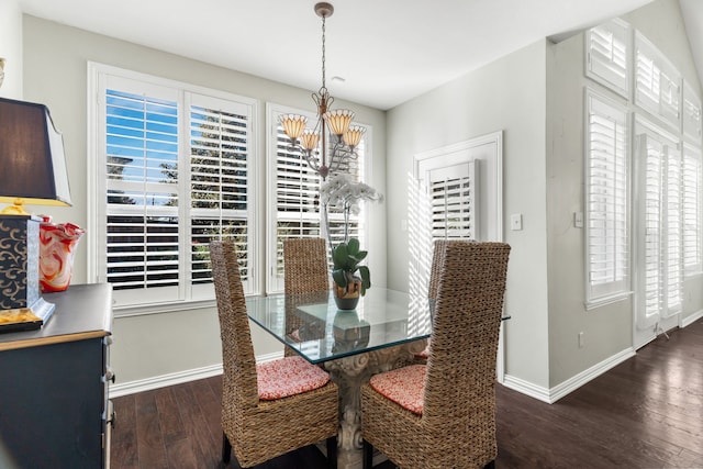 dining area with dark hardwood / wood-style flooring and an inviting chandelier