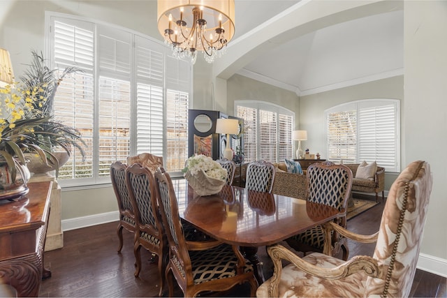 dining space with lofted ceiling, ornamental molding, dark wood-type flooring, and an inviting chandelier