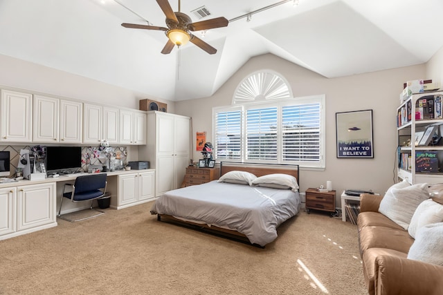 bedroom with ceiling fan, built in desk, light carpet, and vaulted ceiling