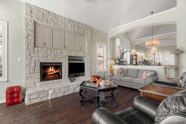 living room with plenty of natural light, a fireplace, a chandelier, and lofted ceiling