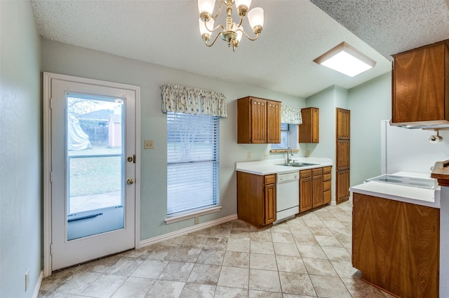 kitchen featuring sink, hanging light fixtures, white dishwasher, a chandelier, and a textured ceiling