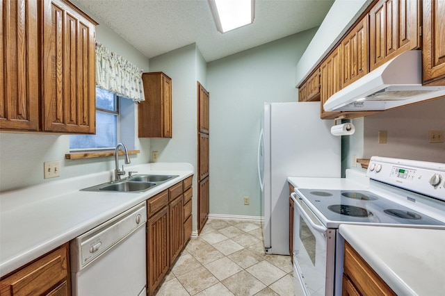 kitchen with a textured ceiling, sink, extractor fan, and white appliances