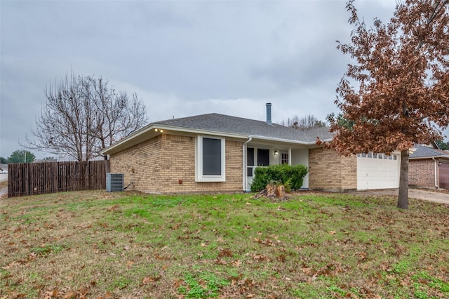 single story home featuring cooling unit, a garage, and a front yard