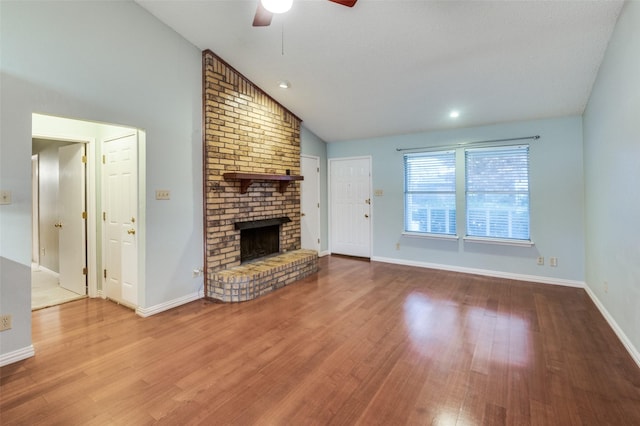 unfurnished living room featuring ceiling fan, a fireplace, hardwood / wood-style floors, and lofted ceiling