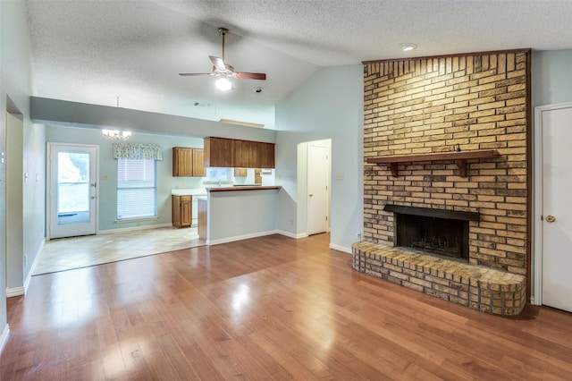 unfurnished living room with a fireplace, a textured ceiling, and lofted ceiling