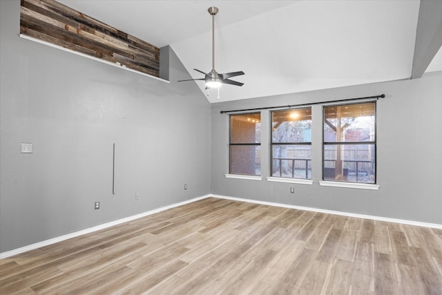 spare room with ceiling fan, vaulted ceiling, and light wood-type flooring