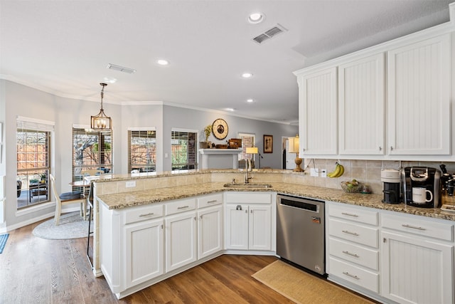 kitchen with kitchen peninsula, dishwasher, hanging light fixtures, and sink