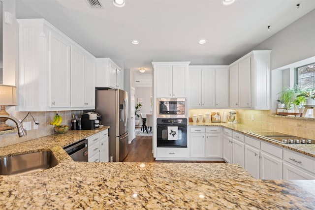 kitchen with dark hardwood / wood-style flooring, tasteful backsplash, sink, black appliances, and white cabinetry