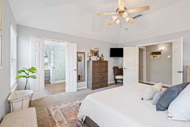 carpeted bedroom featuring ceiling fan, lofted ceiling, and connected bathroom