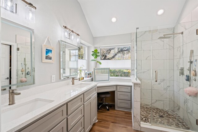 bathroom with wood-type flooring, vanity, vaulted ceiling, and an enclosed shower