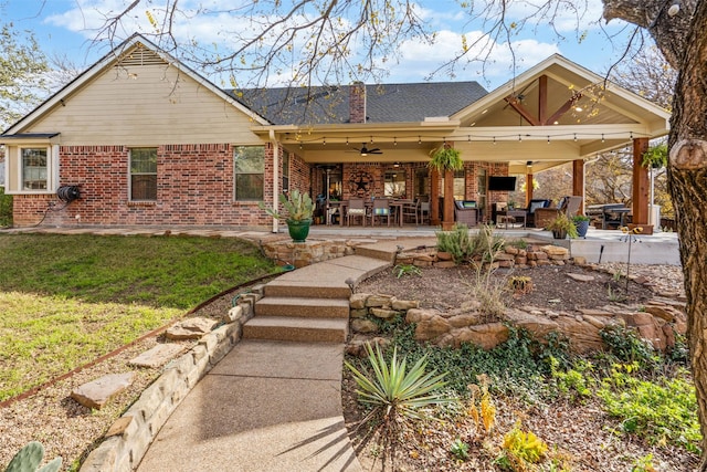 back of property with a yard, ceiling fan, and a patio area