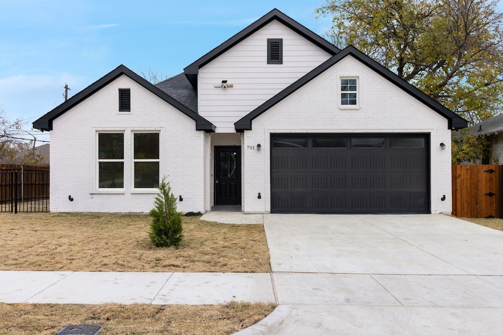 modern inspired farmhouse featuring a garage and a front lawn