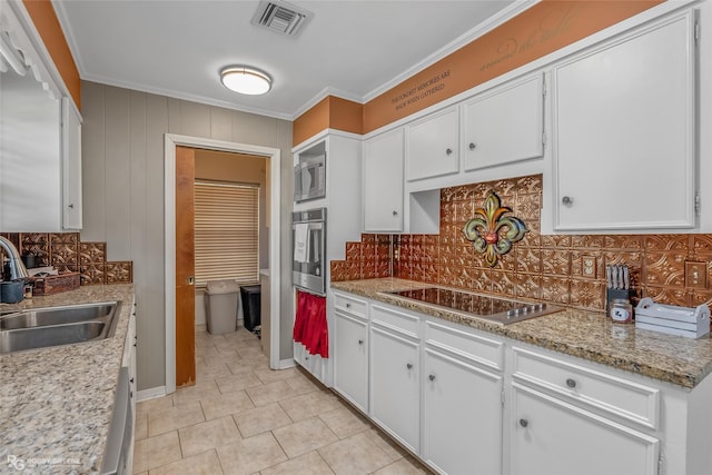 kitchen featuring white cabinets, oven, sink, built in microwave, and electric stovetop