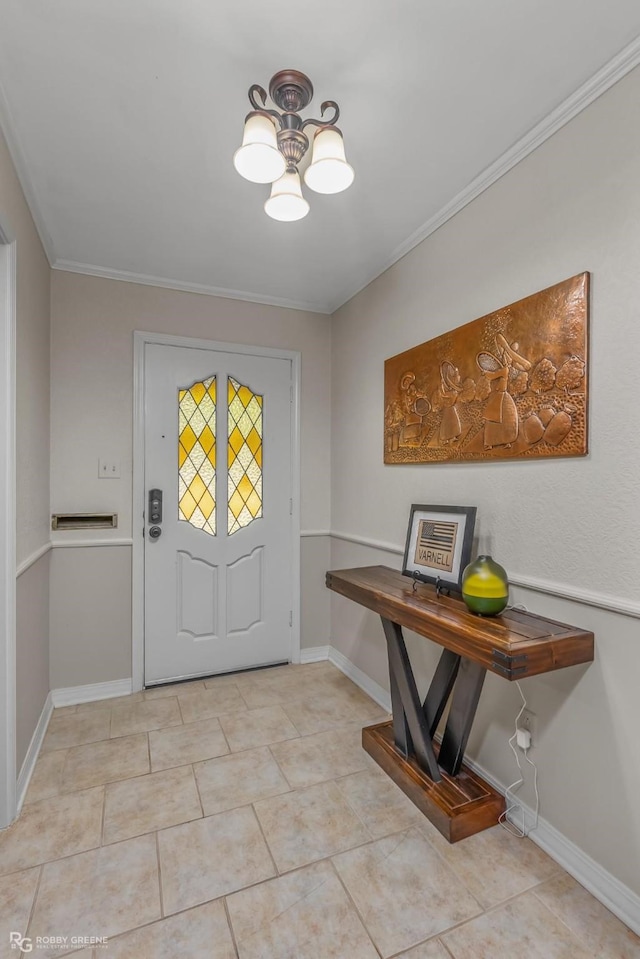 tiled foyer entrance featuring ornamental molding and a chandelier