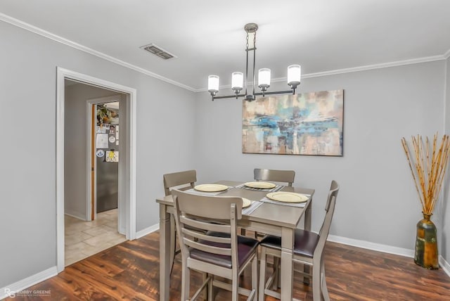 dining area with a chandelier, hardwood / wood-style flooring, and ornamental molding