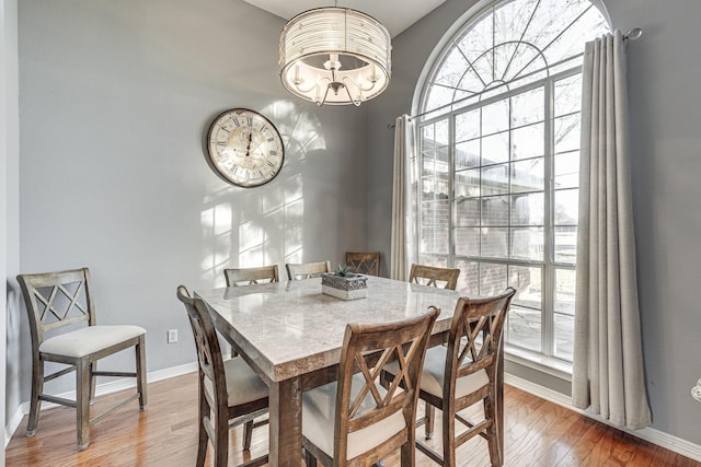 dining space with wood-type flooring and a chandelier